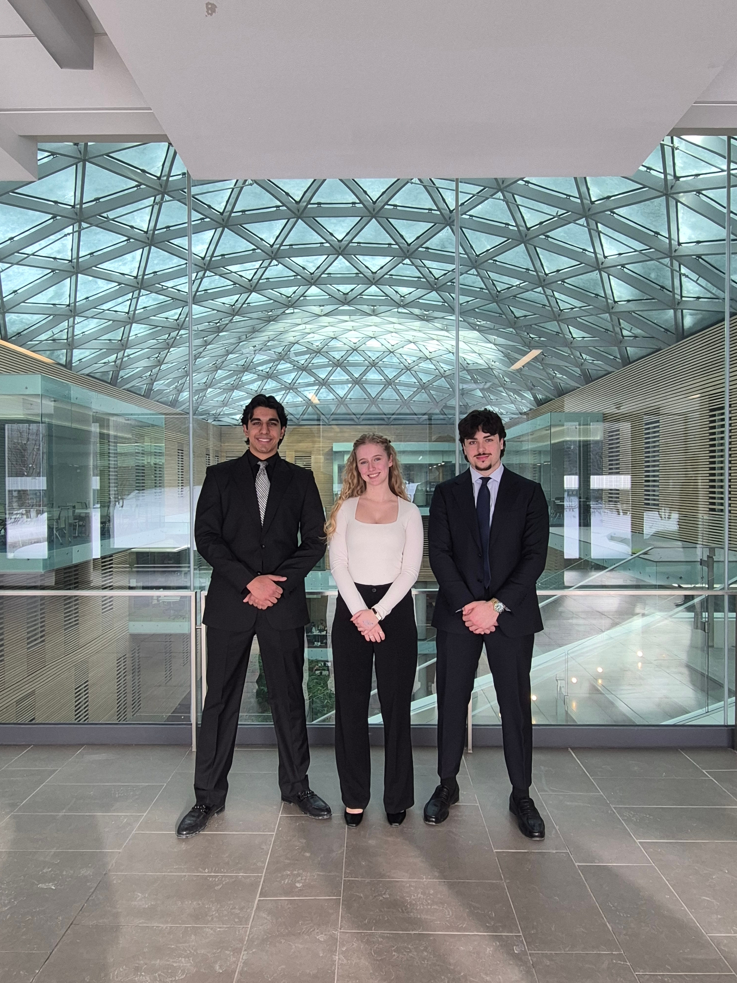 Dilraj Sagoo in a glass atrium with teammates